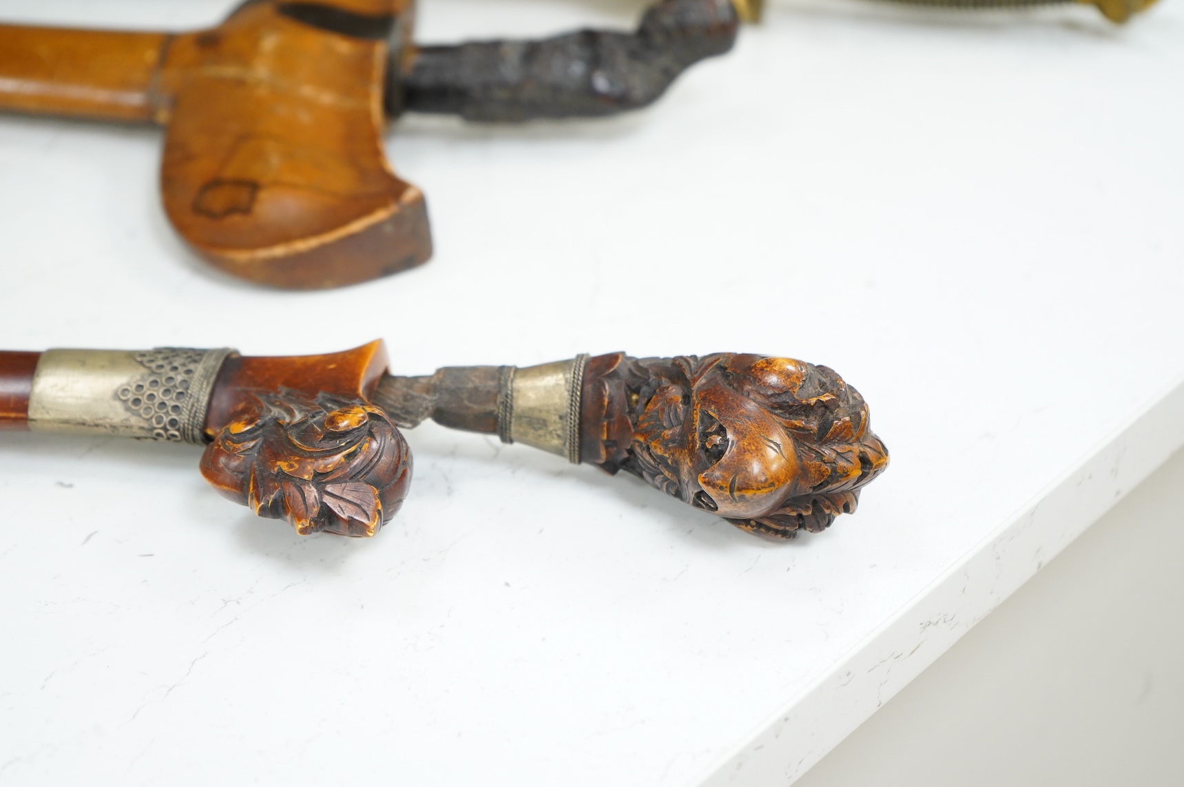 A Javanese dagger kris with straight pamor blade, wooden hilt carved as raksha, in its wooden sheath, together with a decorative dagger bade-bade, with etched blade